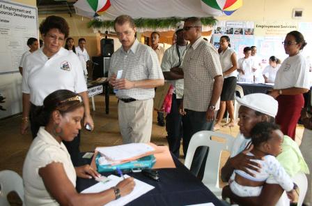 President Michel watches as a job form is filled during the open day at Independence House. On his right is Minister Mondon