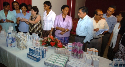 Mr Nag (4th from right) talks to Minister Lloyd after handing over the medicine to Mrs Larue (6th from right)