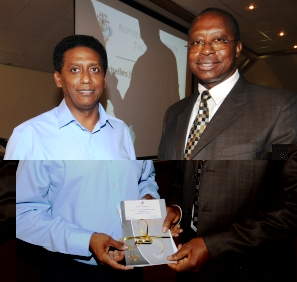 Chief Justice Egonda-Ntende (right) hands over copies of the strategic plan and code of judicial conduct to VP Faure