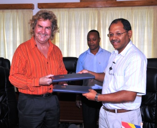 Mr Afif (right) and Mr Geerz exchange documents after signing the agreement