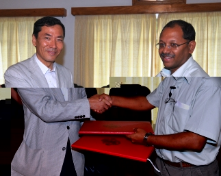 Mr Takata (left) and Mr Afif exchange documents after signing the agreement