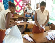 A group of secondary students watch as some Visual Arts students display tie and dye techniques